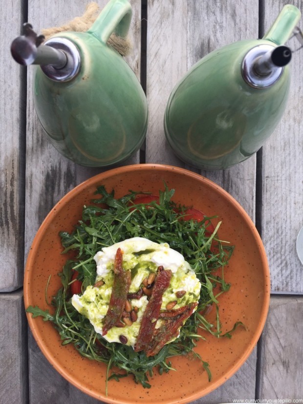 Ensalada de burrata, rúcula, tomate y pesto suave.