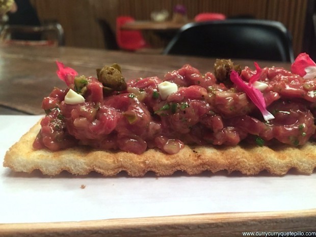 Steak tartar de buey en tostada. Carne melosa y picante (de chile) acompañada de alcaparras fritas y crujientes y una tostada perfecta para tomar con las manos. (Le Bouchon, Barcelona)